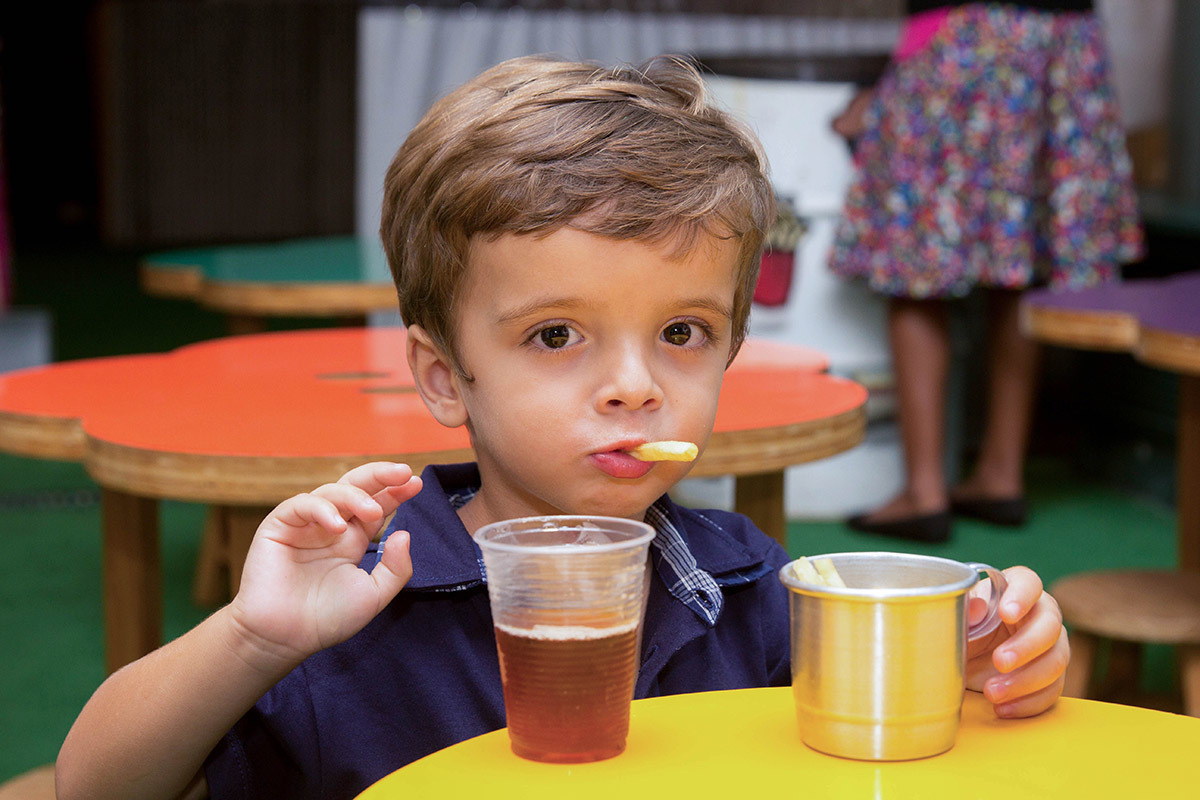 Festa de aniversário do Mateus: Mateus, 3 anos, comendo batata frita - Rio de Janeiro.