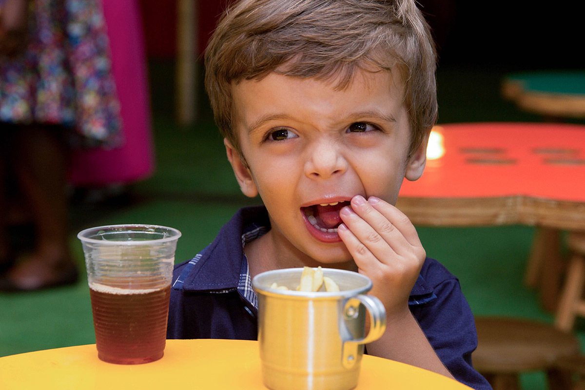 Festa de aniversário do Mateus: Mateus, 3 anos, comendo batata frita - Rio de Janeiro.