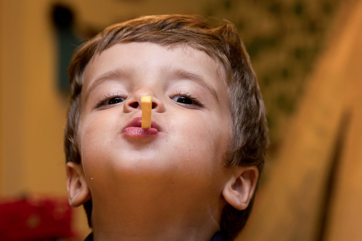 Festa de aniversário do Mateus: Mateus, 3 anos, comendo batata frita - Rio de Janeiro.