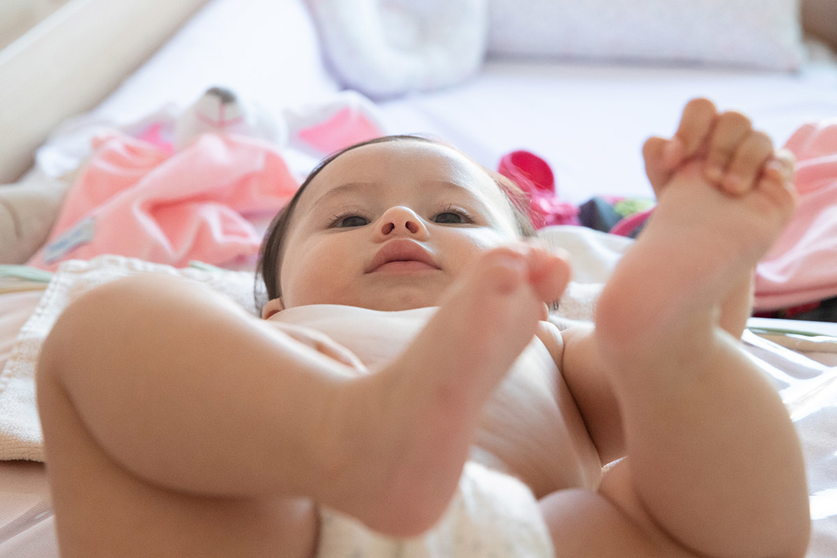 Maitê deitada no trocador com as pernas para o alto - ensaio de bebê - Rio de Janeiro - RJ.