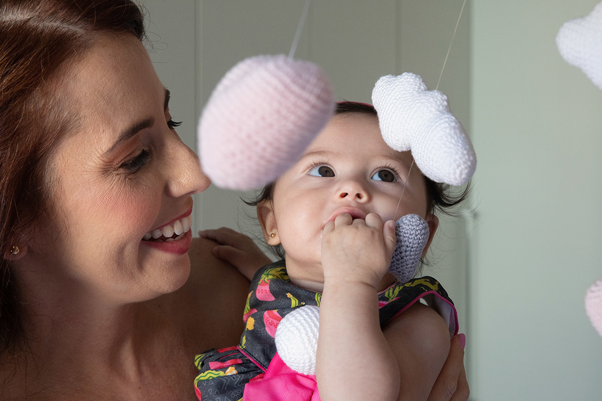 Maitê no colo da mãe brincando  - ensaio de bebê - Rio de Janeiro - RJ.