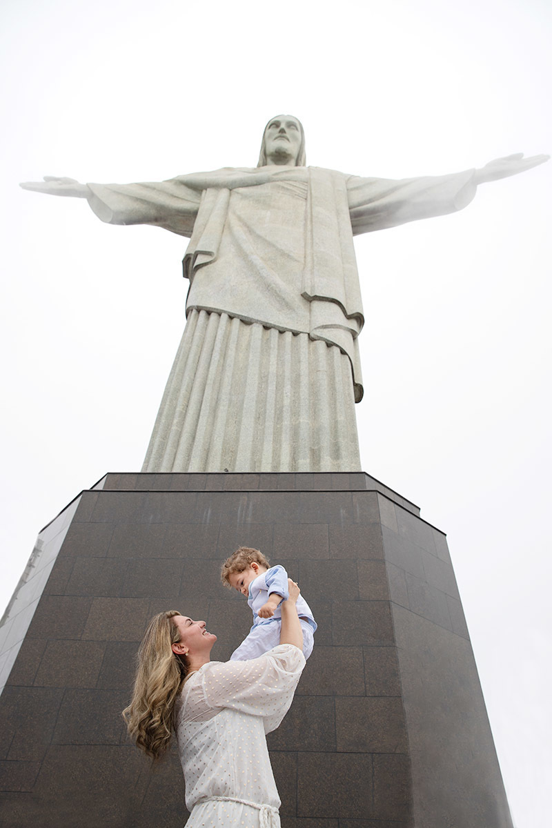 Batizado do Vitor: Mãe levantando o Vitor em direção ao Cristo Redentor no Corcovado, no Rio de Janeiro.