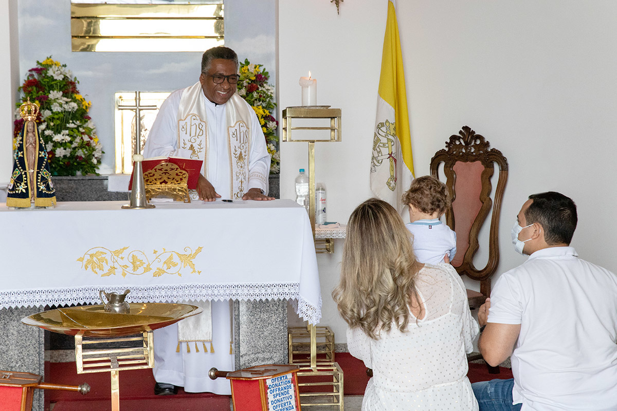 Batizado do Vitor: Mãe, pai e padre com o Vitor dentro da capela do Corcovado, no Rio de Janeiro.