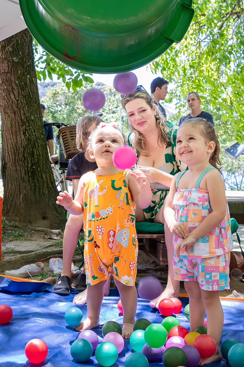 Crianças brincando com bolinhas coloridas na festa Piquenique da Alice na Lagoa no Rio de Janeiro