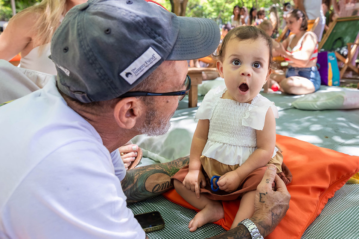 Alice bocejando ao lado de seu avô durante a sua festa de 1 ano na Lagoa no Rio de janeiro