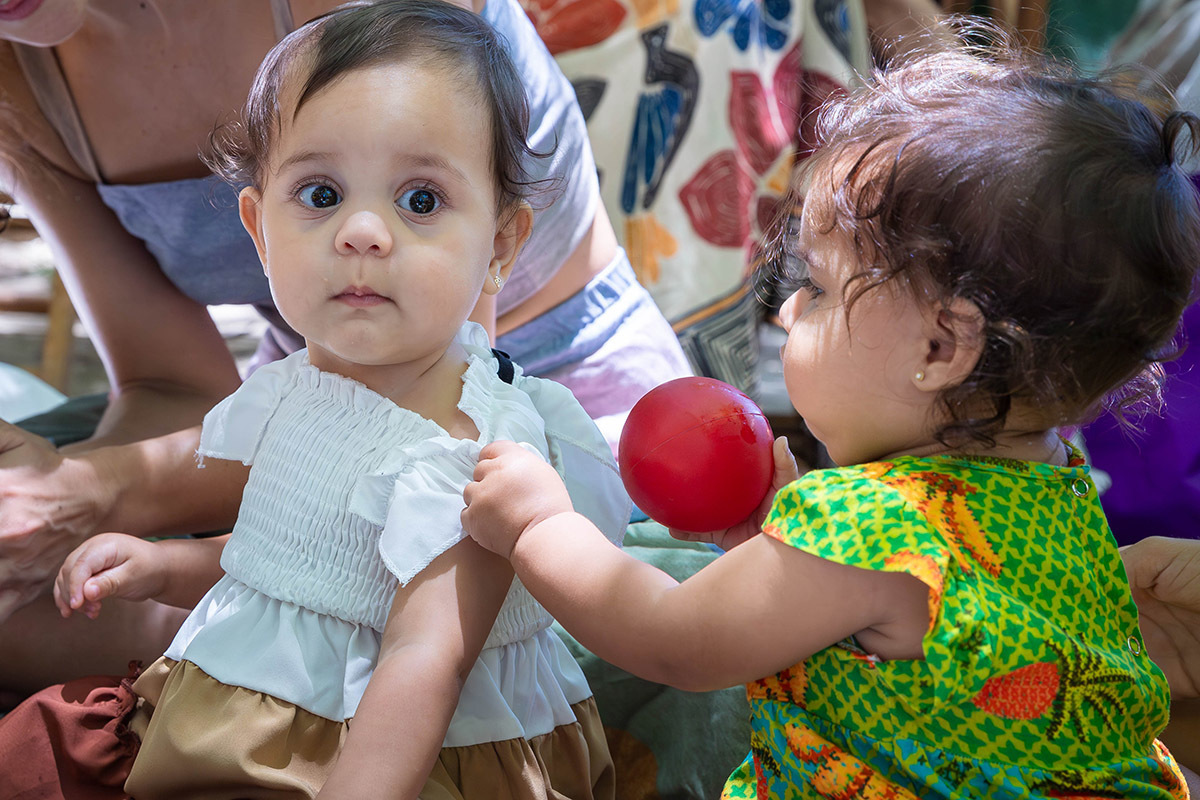 Criança puxando a Alice para brincar em sua festa Piquenique de 1 ano na Lagoa no Rio de Janeiro