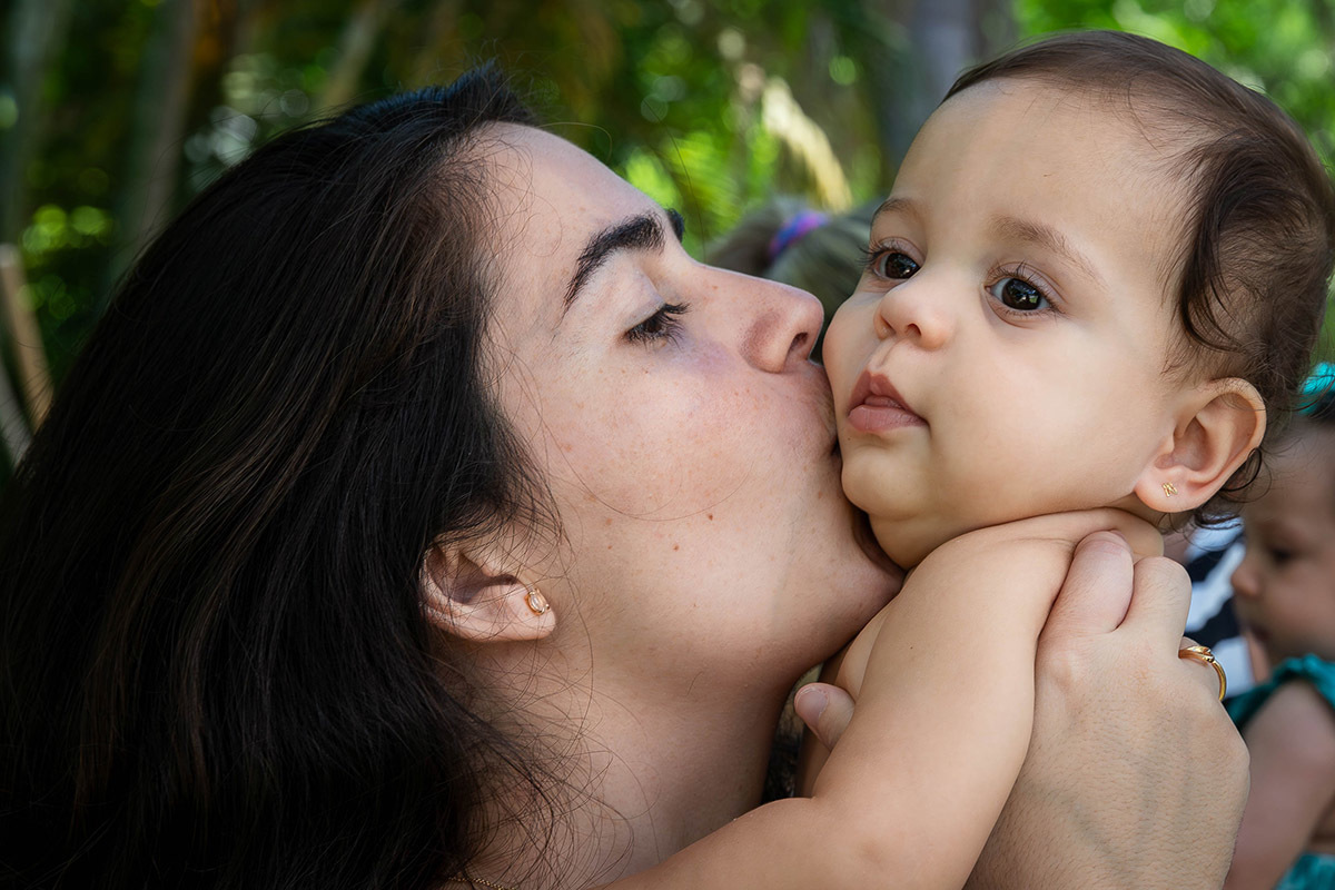 Luiza beijando a bochecha da Alice em sua festa na Lagoa no Rio de Janeiro