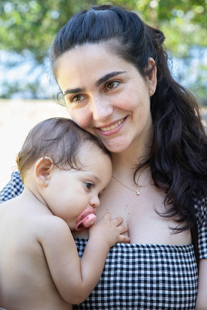 Alice no colo da mãe durante a festa Piquenique na Lagoa no Rio de janeiro