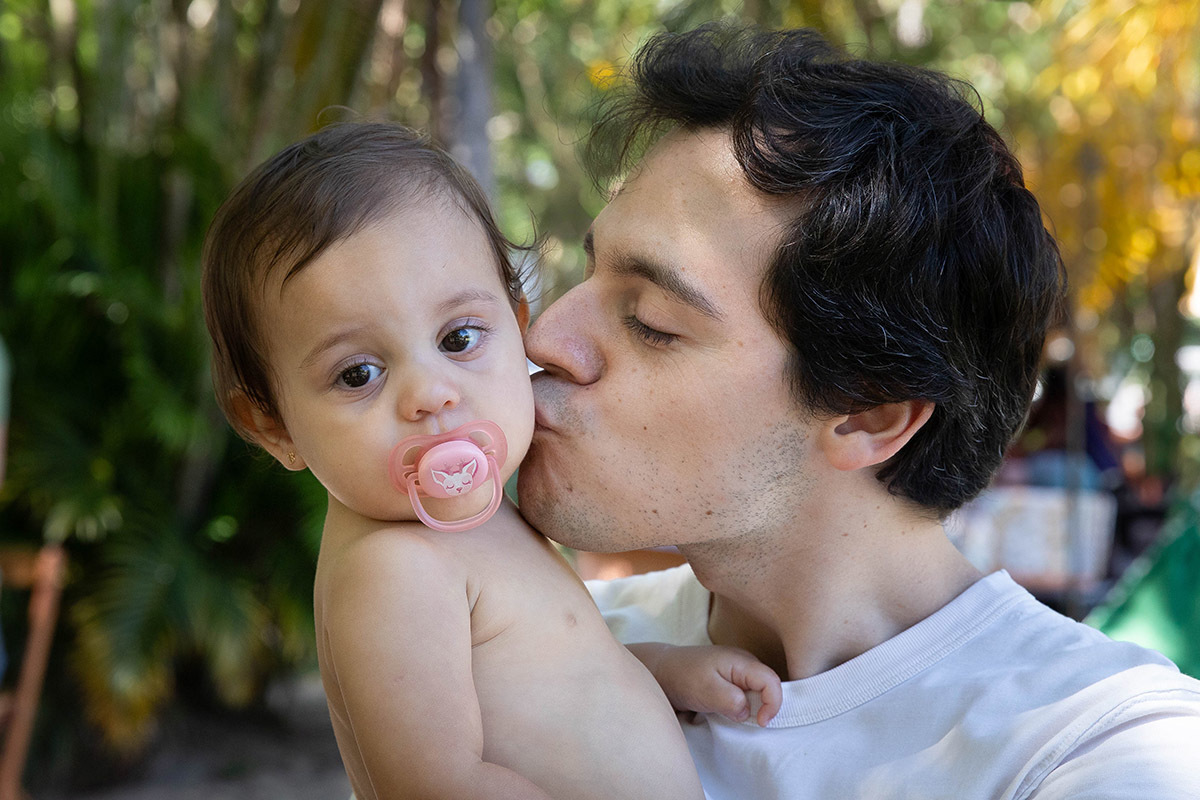 Pai da Alice dando beijo na sua bochecha durante a festa Piquenique na Lagoa no Rio de Janeiro