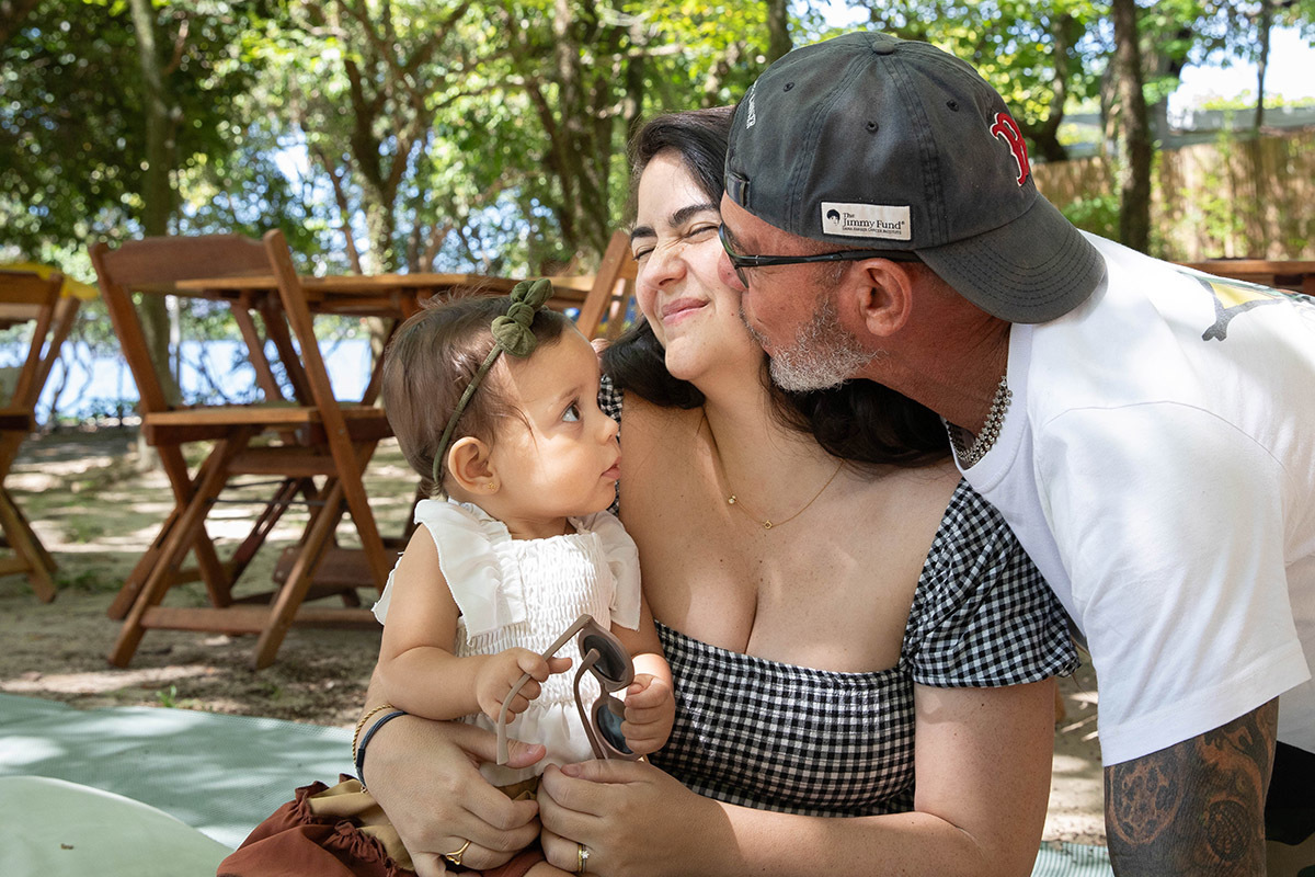pai beijando a filha que está com a alice de 1 ano no colo na festa de aniversário de 1 ano no Rio de Janeiro