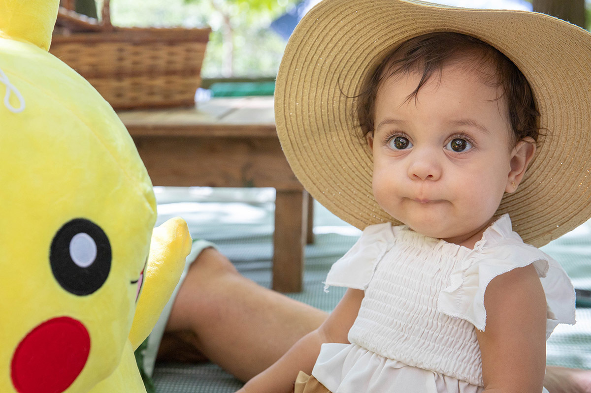 alice de chapéu de palha ao lado do Pikachu na festa de aniversário de 1 ano no Rio de Janeiro