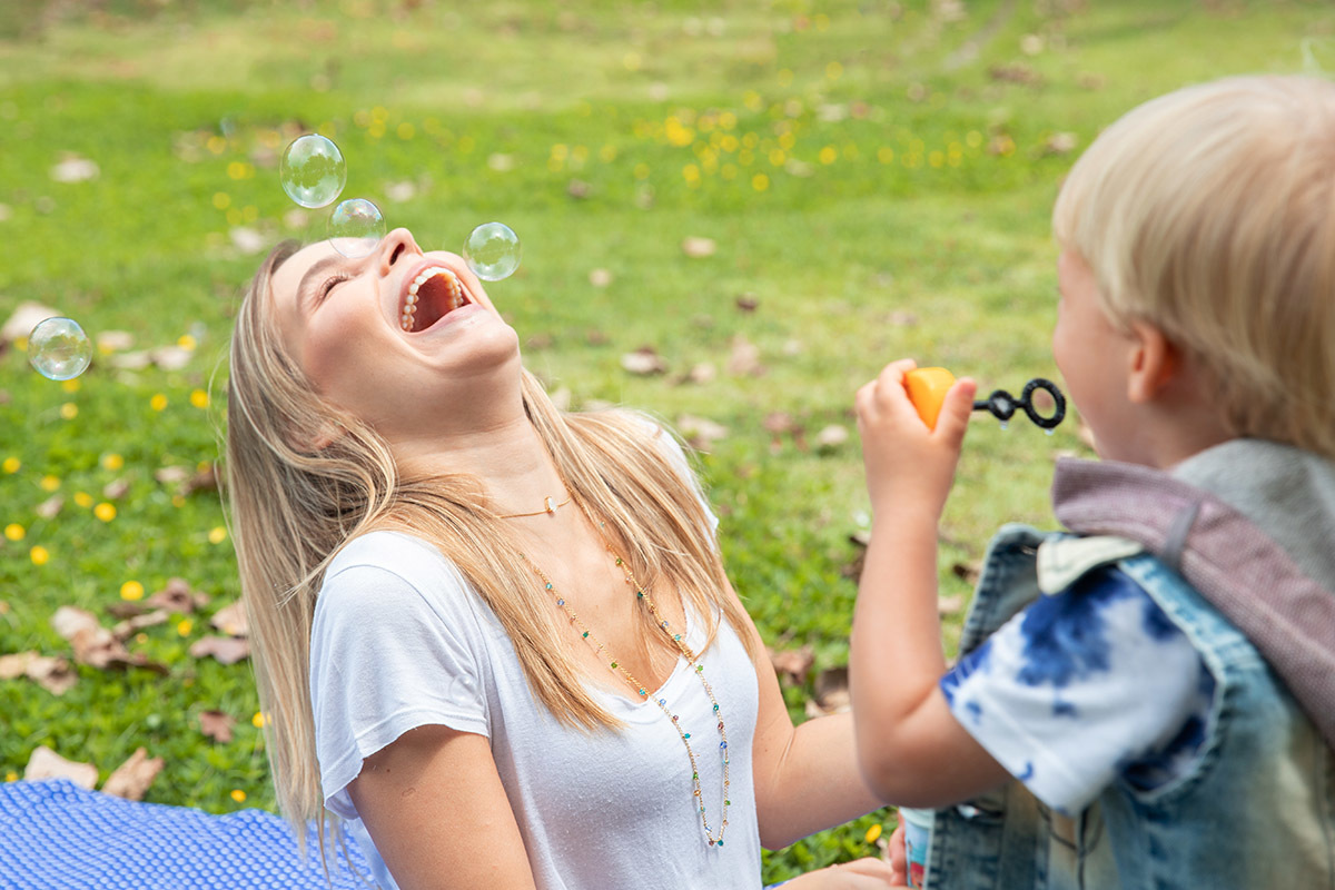 mãe e filho se divertindo com bolhas de sabão em ensaio na lagoa rj