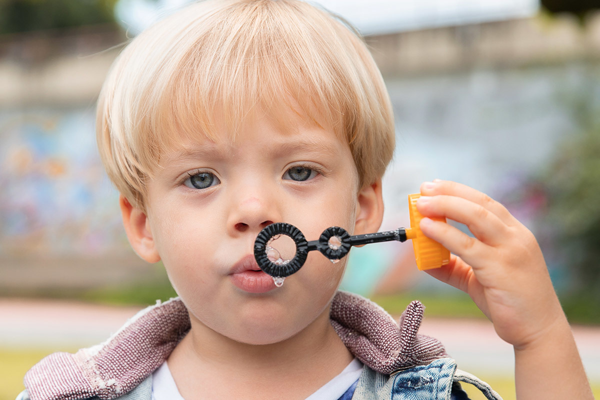 Bolhas de sabão no rosto do menino durante ensaio infantil na Lagoa

