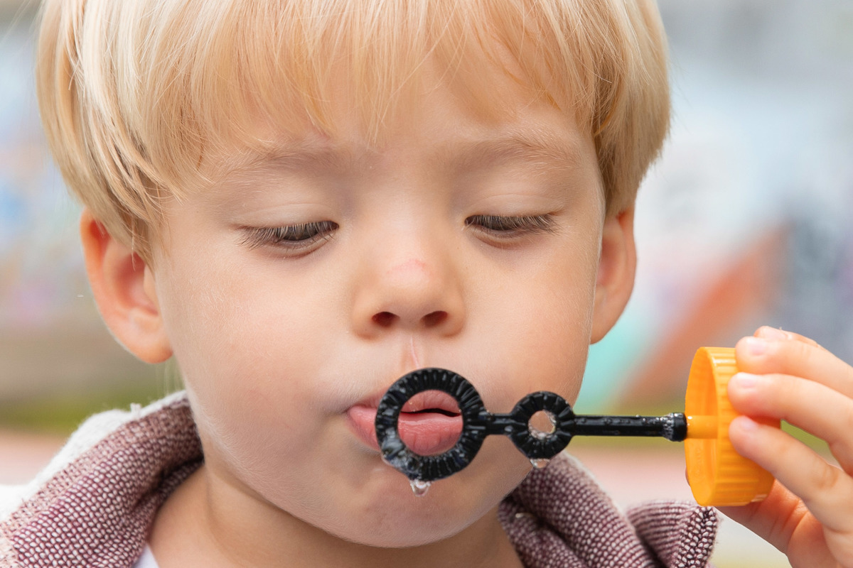 Menino concentrado fazendo bolhas de sabão em ensaio de família no Rio

