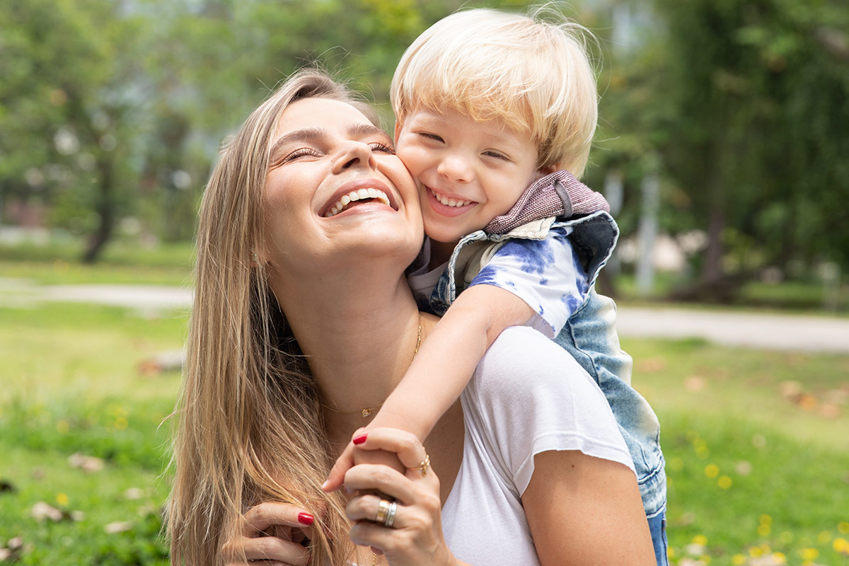 Mãe segurando o filho nos braços em momento de afeto no ensaio fotográfico

