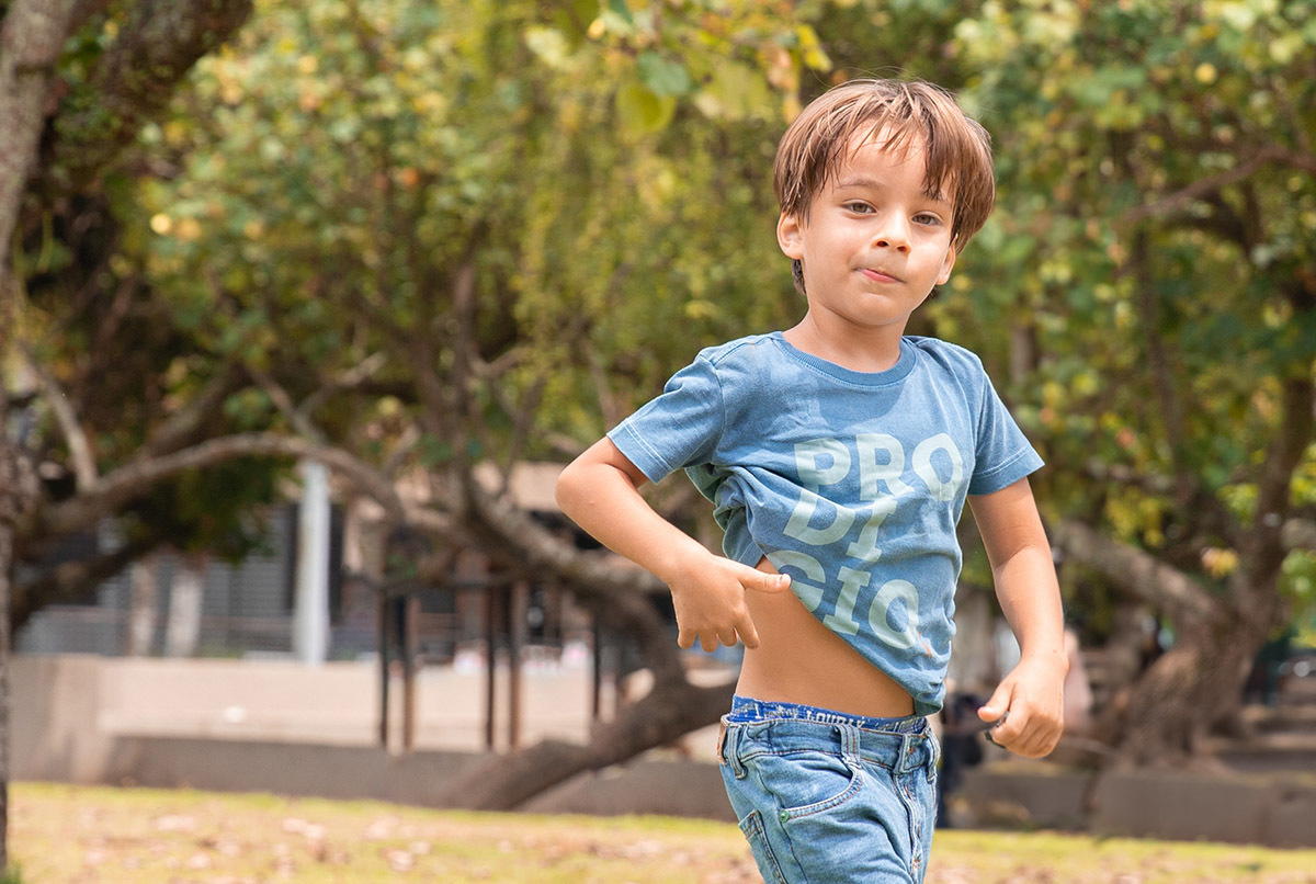 Criança em pé no gramado durante ensaio fotográfico na Lagoa do RJ

