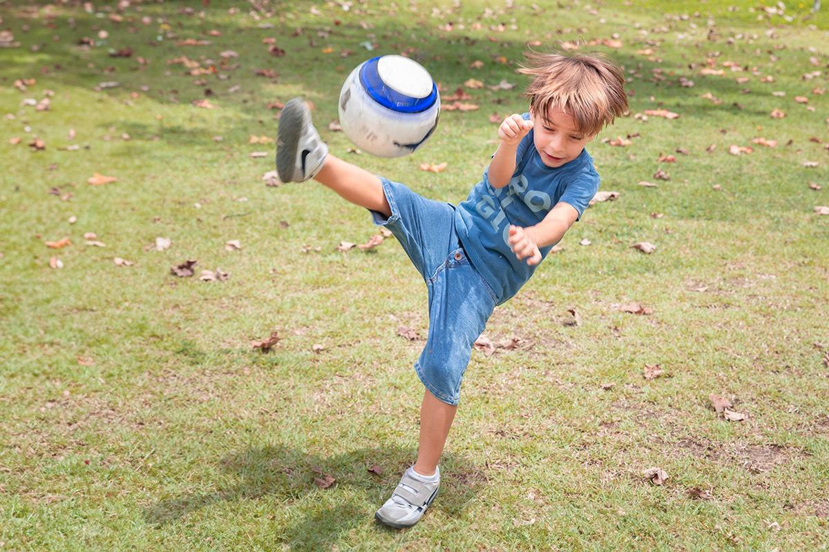 Menino jogando bola na Lagoa Rodrigo de Freitas


