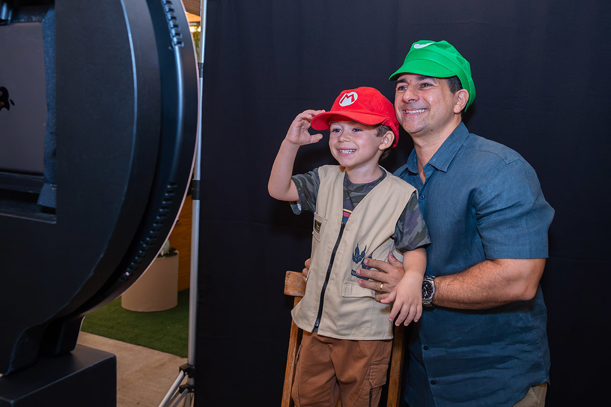 Criança brincando como pai na cabine de fotos em festa temática Jurassic Park RJ
