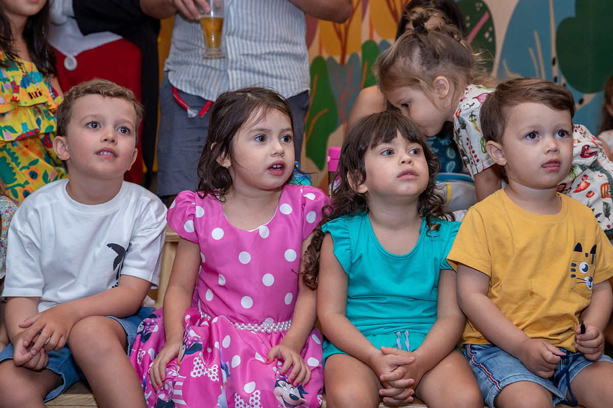 Meninos concentrados na hora do teatrinho durante festa infantil temática