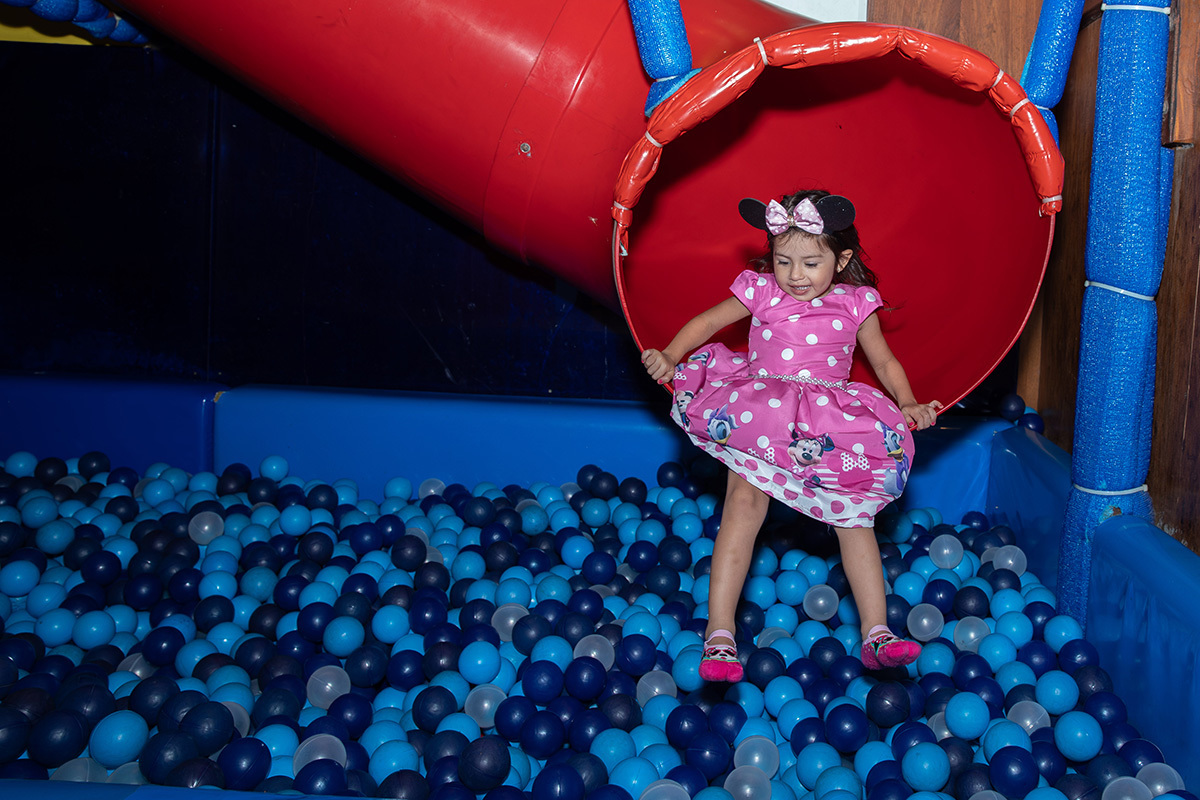 Aniversariante descendo pelo tobogã até a piscina de bolinhas na festa infantil na casa de festa espoleta