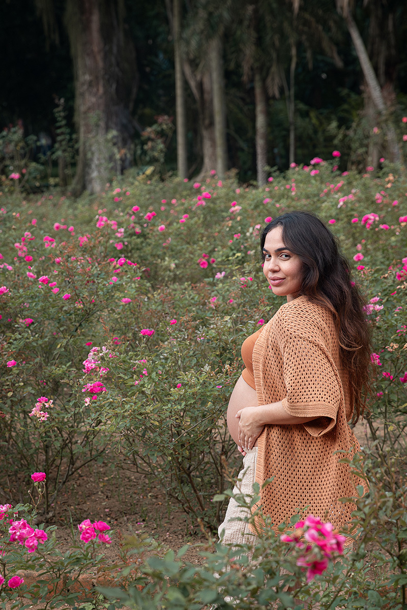 Foto de grávida sorrindo no roseiral do jardim Botânico