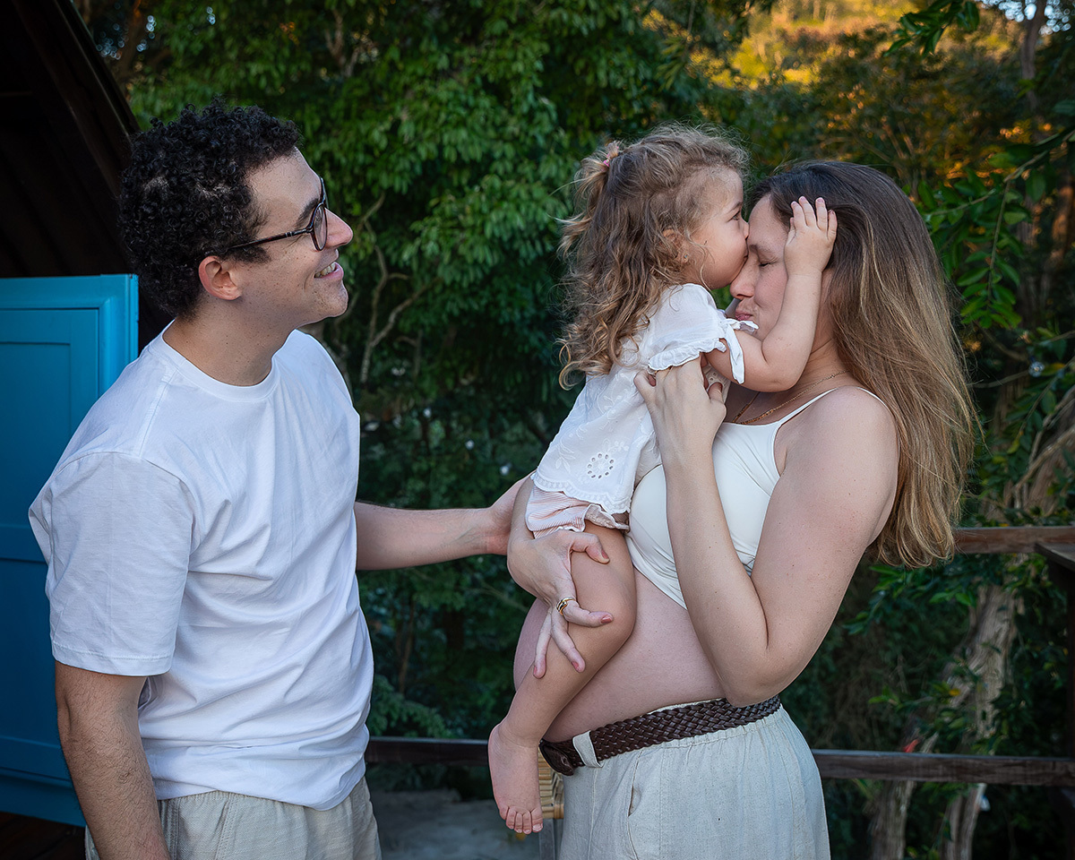 Pedro e Sofia beijam a Jessica durante um momento cheio de carinho no ensaio gestante.