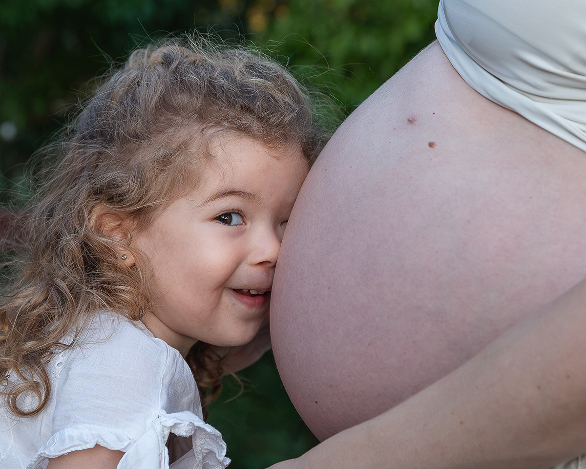 Sofia em momento de carinho com a barriga da mamãe demonstrando todo o amor pelo irmão Guilherme.