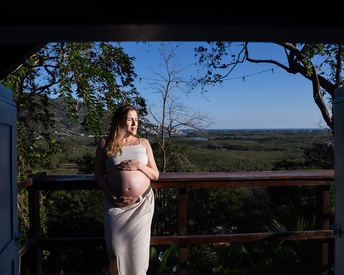 Retrato da gestante ao pôr do sol com vista para a natureza em ensaio gestante ao ar livre.