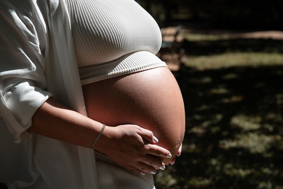 detalhe da barriga da gestante com luz criativa