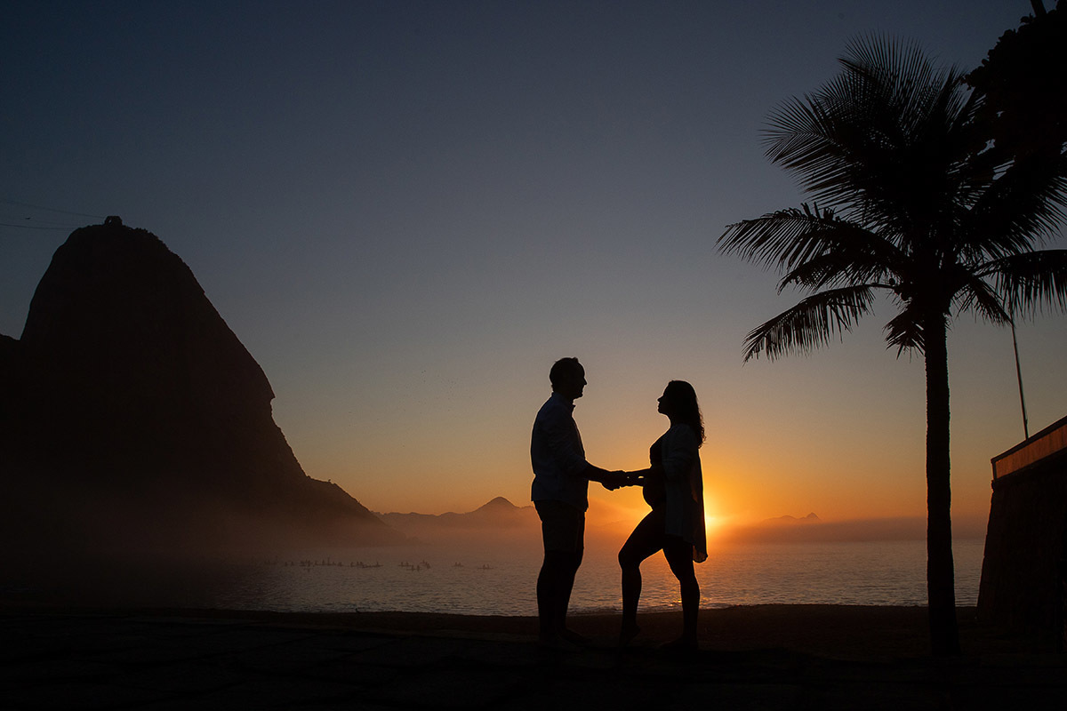 Silhueta de casal durante ensaio gestante no amanhecer na Praia Vermelha