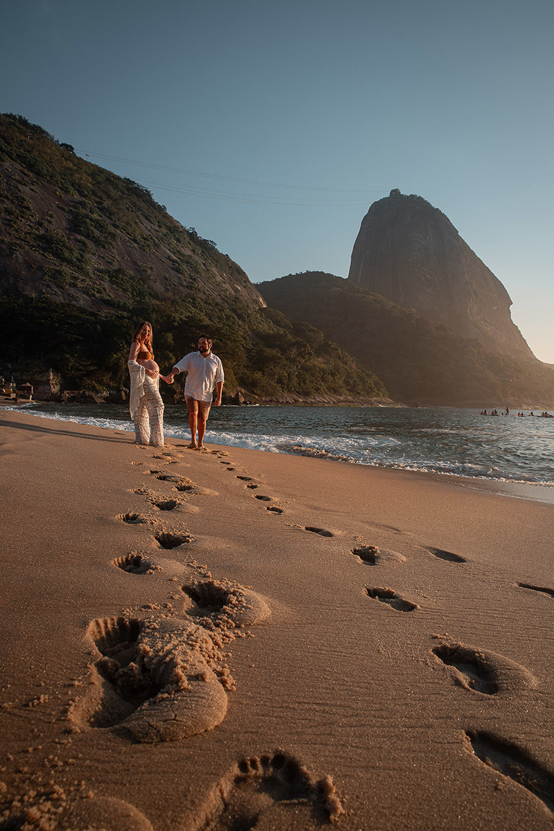 Casal esperando o bebê com cenário carioca ao fundo na Praia 