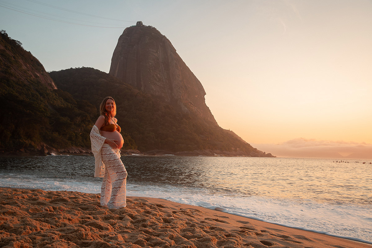 Gestante na areia em frente ao mar co o morro da urca ao fundo 