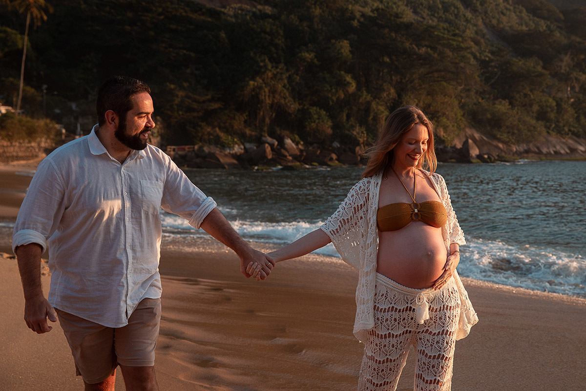 Casal em momento descontraído andando na areia na Praia Vermelha