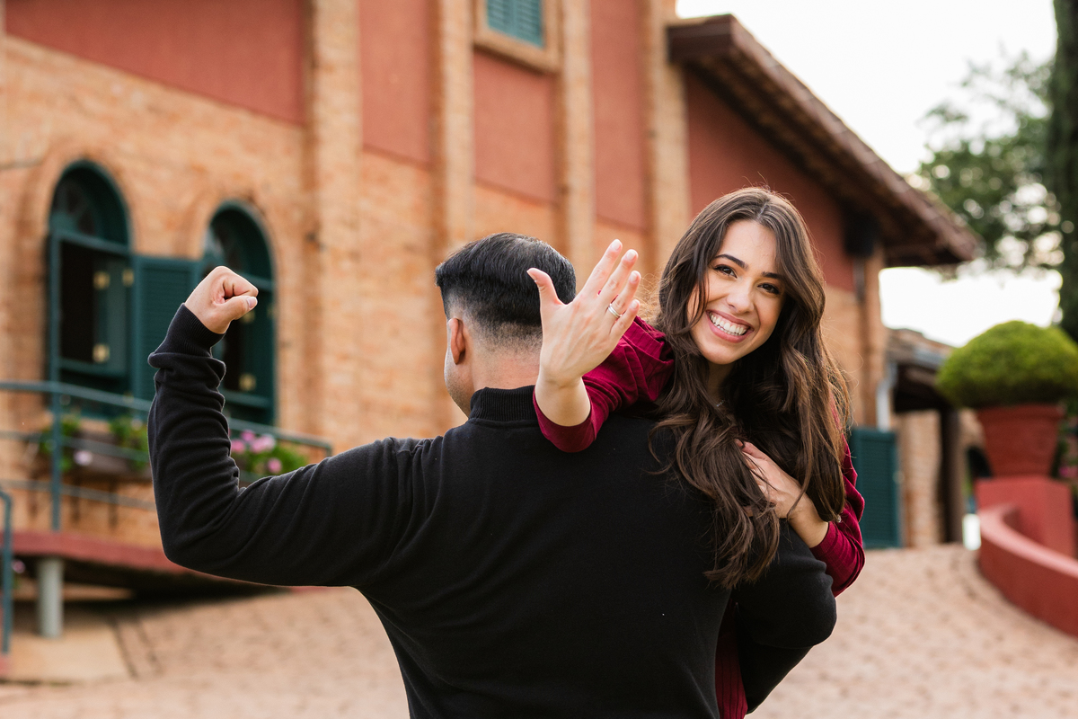 casal nos ombros noivo mostrado mão cm aliaça de noivado casal brindando Vinhos Micheletto - vinícola e vinhedo louveira e itatiba