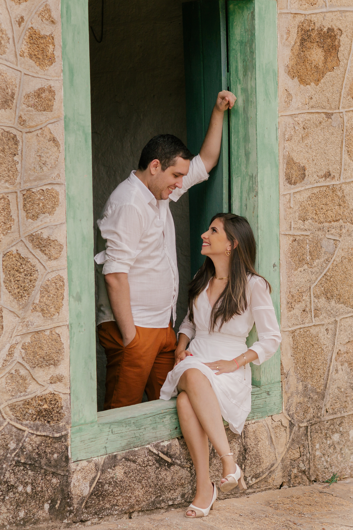 ensaio fotografico pre wedding casal noiva sentada na janela e noivo trocando olhares