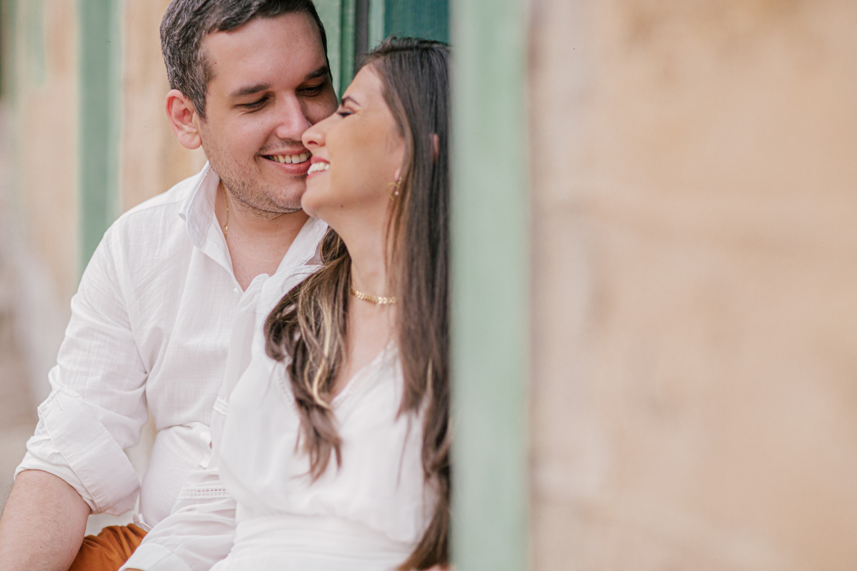 ensaio fotografico pre wedding casal  sentados e sorrindo um para o outro