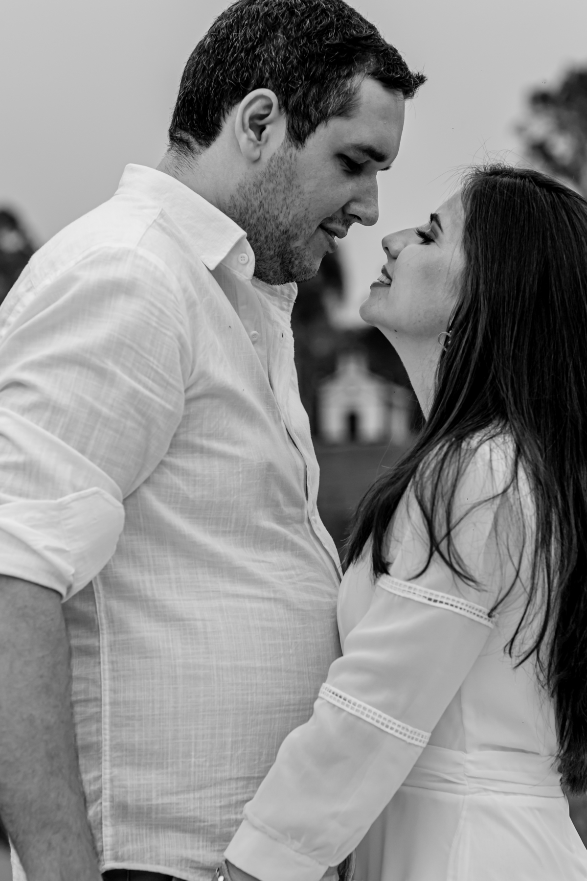 ensaio fotografico pre wedding casal com igreja desfocada ao meio deles