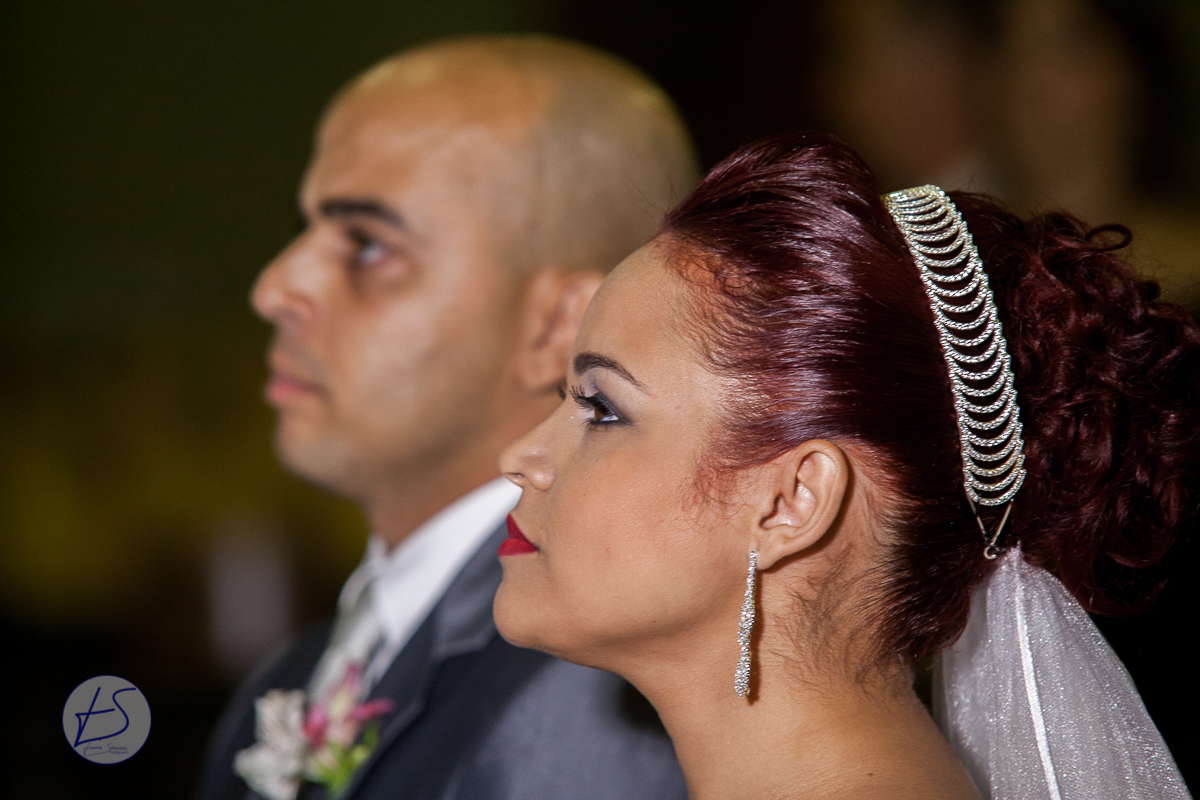 Foto em close dos rostos do casal com a noiva em primeiro plano e em segundo plano com um leve desfoque está o noivo