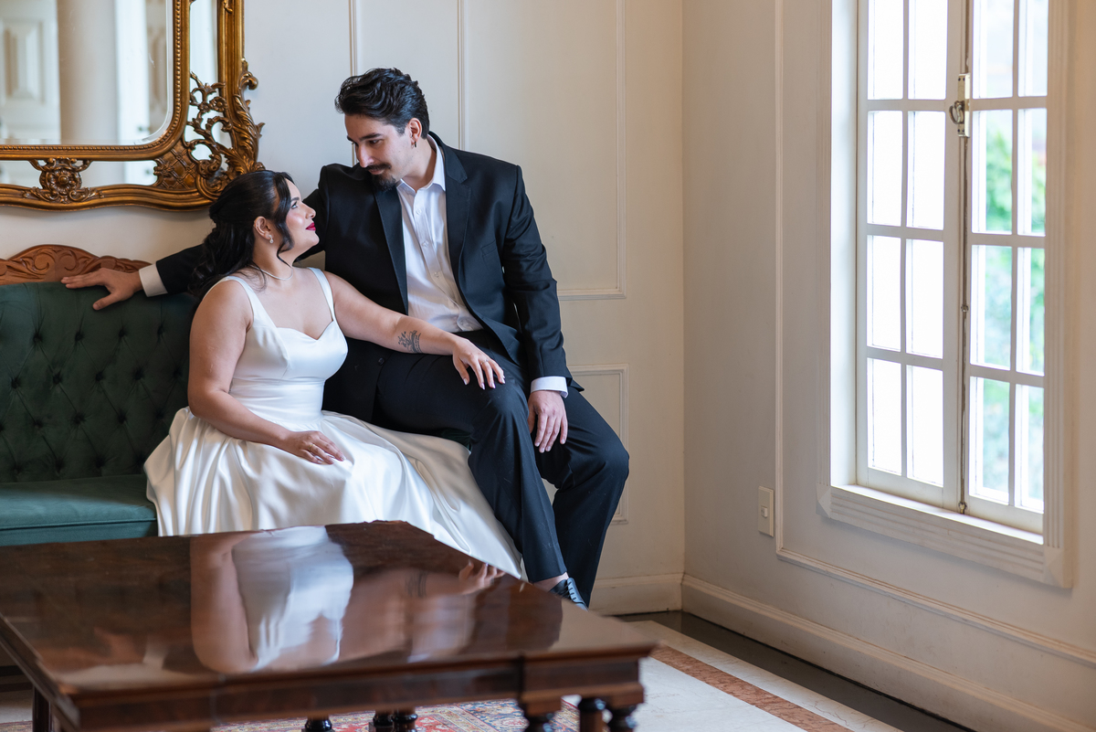 Ensaio de casal naEnsaio fotográfico na Casa Cenarium em Nova Lima MG, casal sentado em ambiente interno clássico, com fotografia elegante e atemporal. Casa Cenarium 