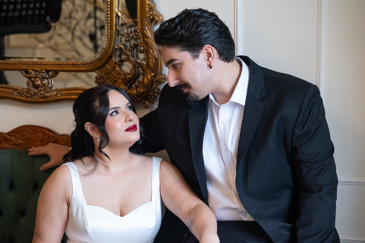 Ensaio fotográfico na Casa Cenarium em Nova Lima MG, casal sentado em ambiente interno clássico, com fotografia elegante e atemporal.