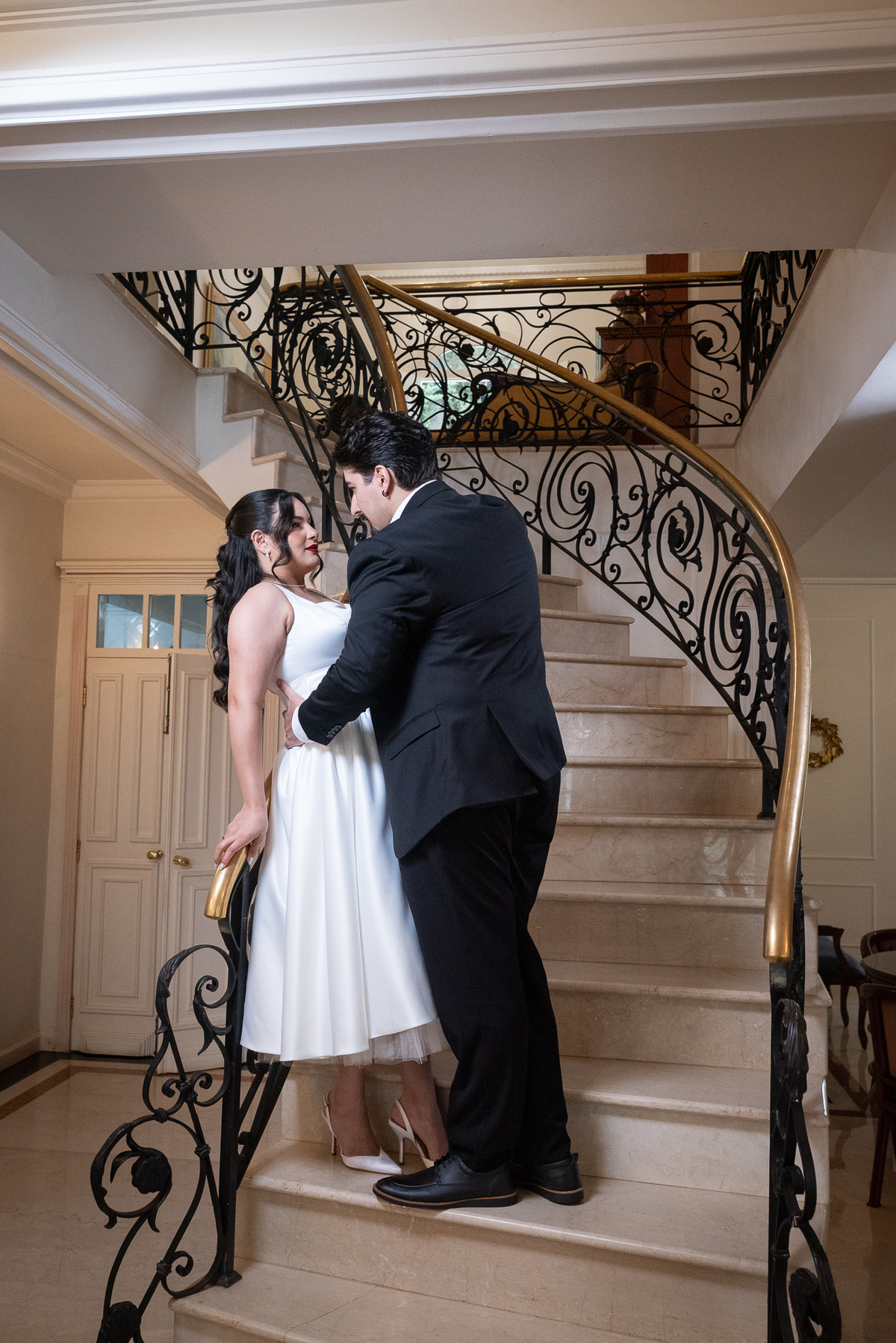 Ensaio de casal conceitual na Casa Cenarium em Nova Lima, com fotografia artística em escadaria clássica e clima cinematográfico.