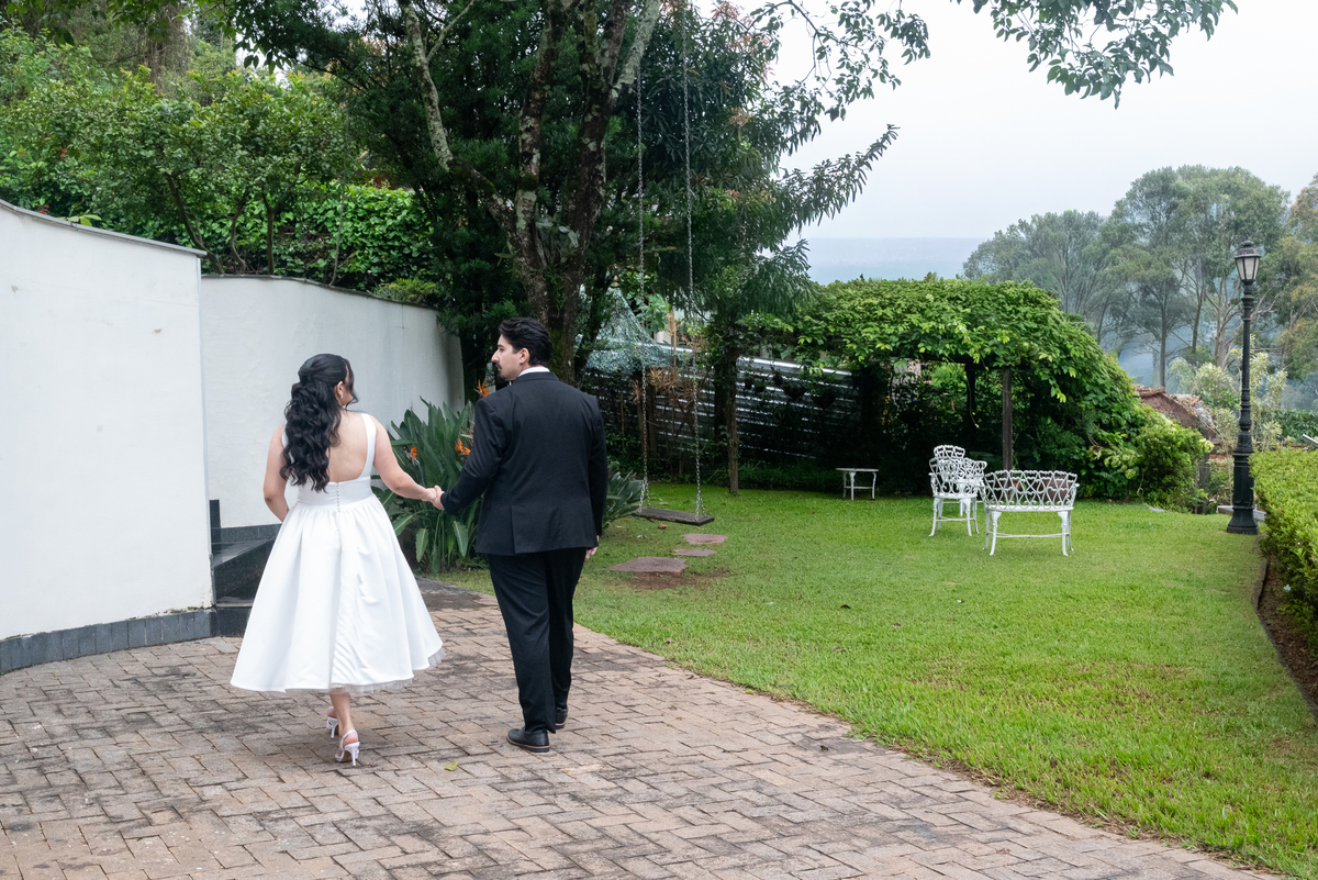 Ensaio fotográfico de casal na Casa Cenarium em Nova Lima MG, com Camila e Igor caminhando ao ar livre em um cenário elegante e rodeado pela natureza.