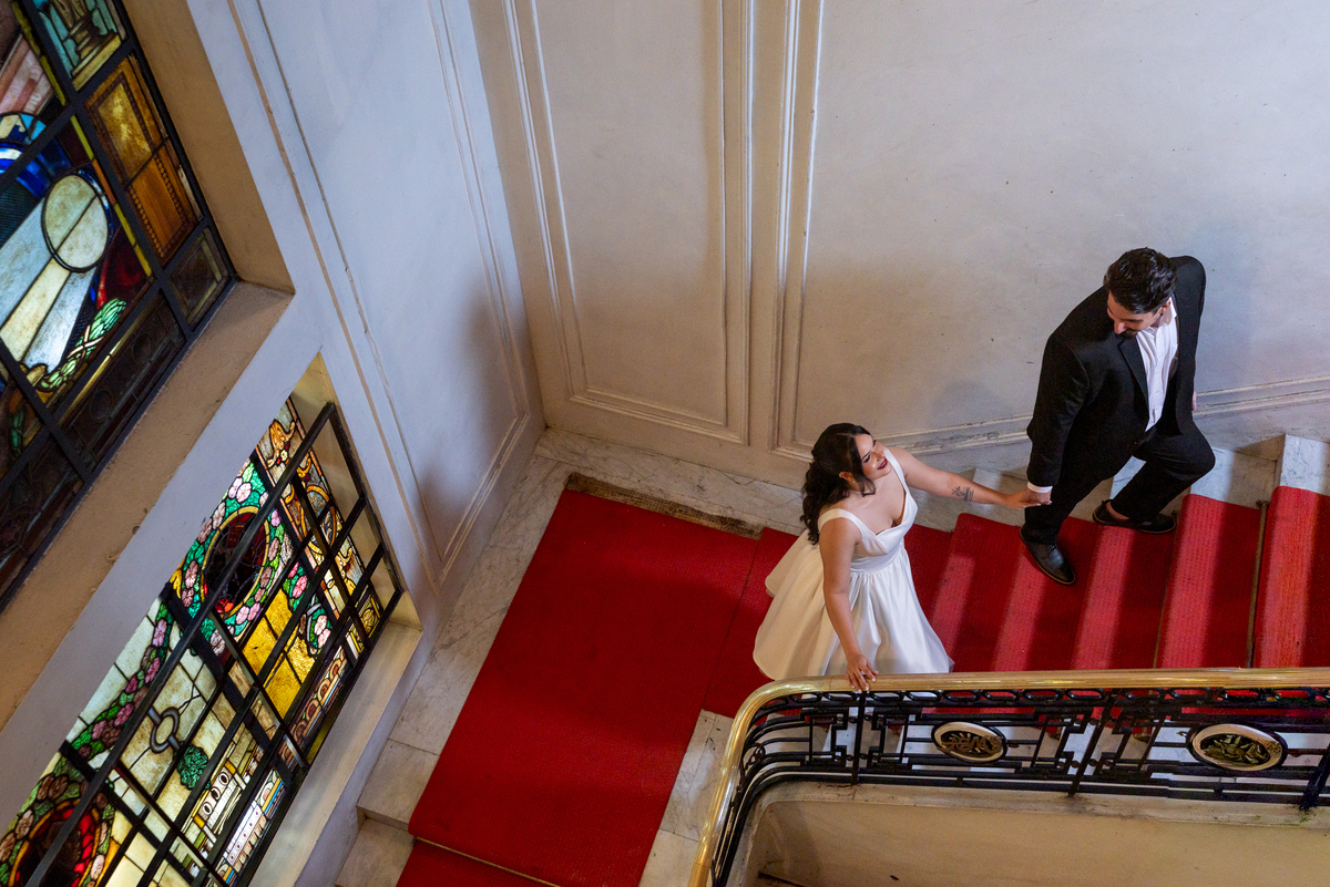 Ensaio de casal conceitual no Automóvel Clube de Belo Horizonte, com fotografia artística em escadaria clássica.