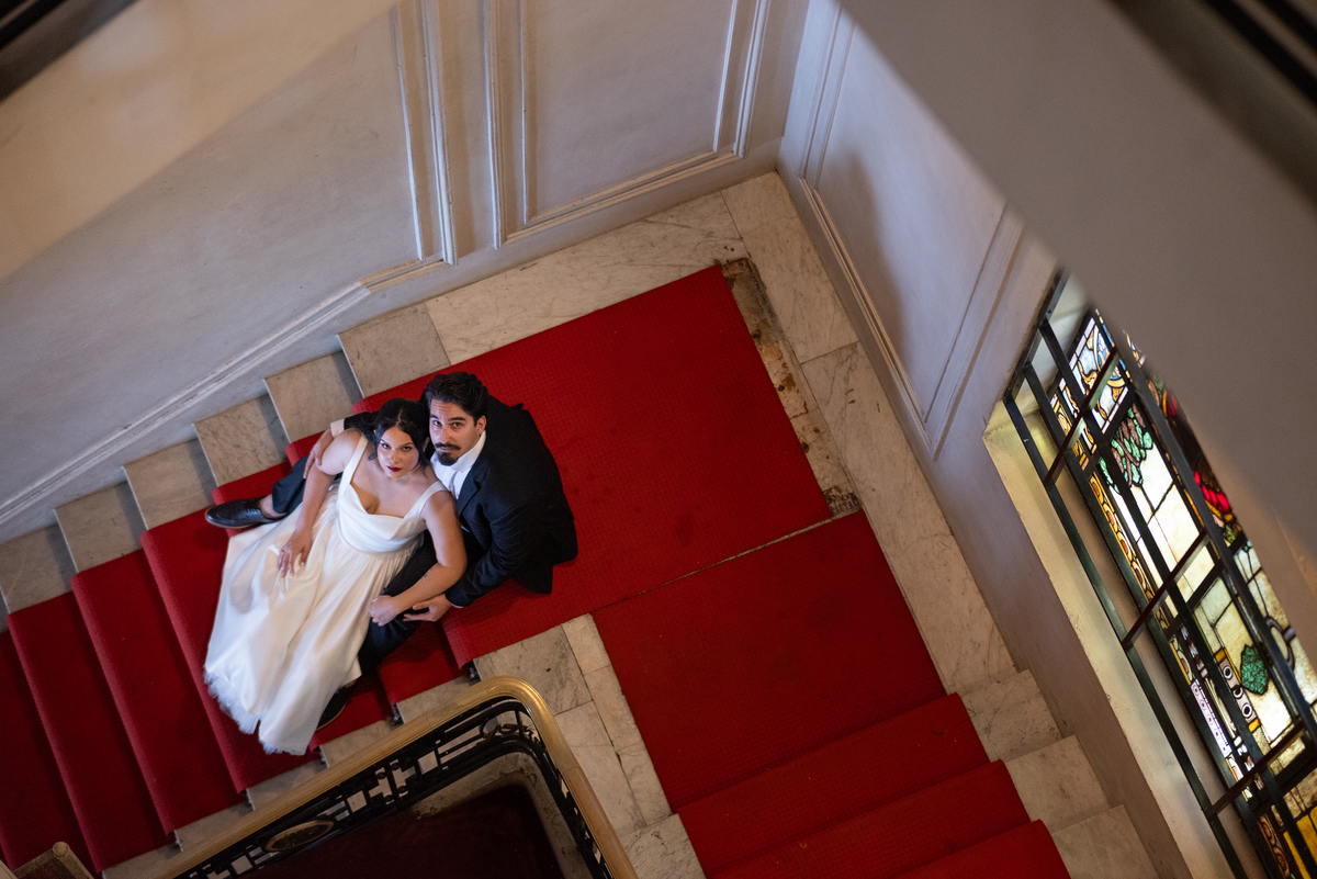 Ensaio de casal conceitual no Automóvel Clube de Belo Horizonte, com fotografia artística em escadaria clássica.