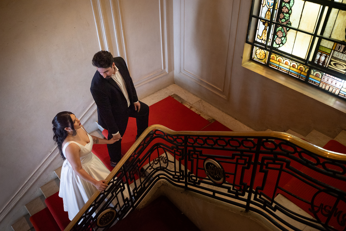 Ensaio de casal conceitual no Automóvel Clube de Belo Horizonte, com fotografia artística em escadaria clássica.