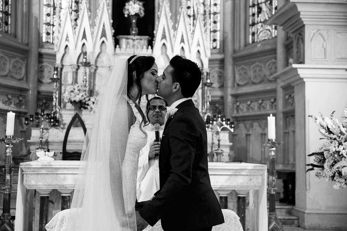 o casal em primeiro plano em uma foto preto e branca de juca sousa enquanto o padre aparece por entre o casal