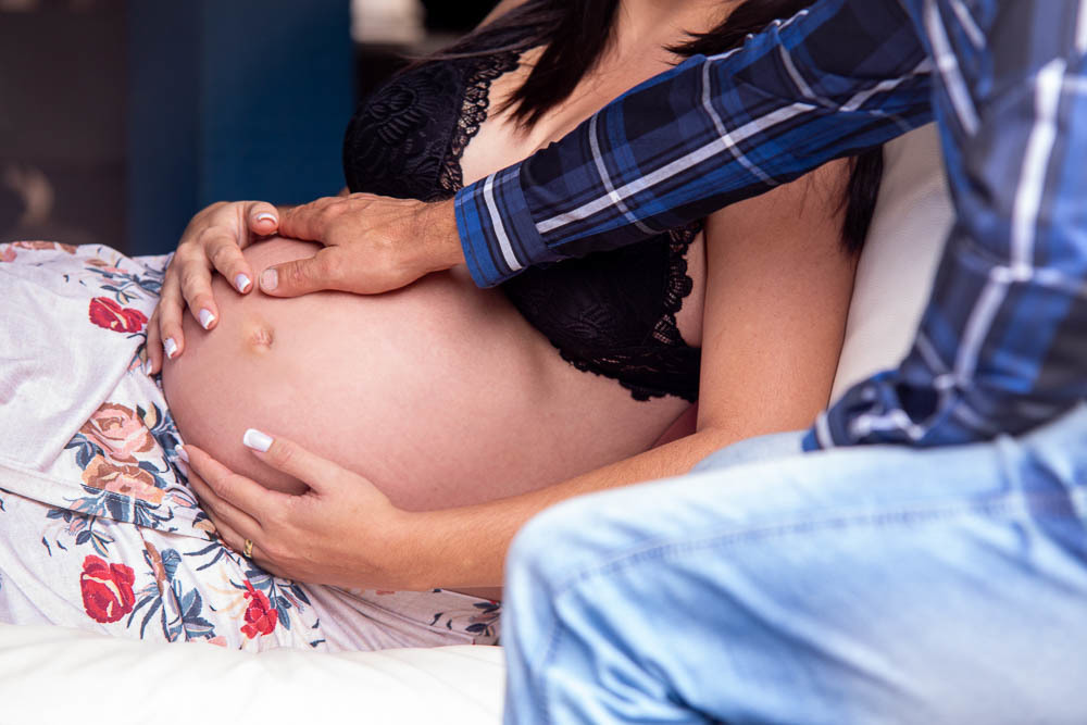 ensaio de gestante Bouganville Farm em Caeté gestante com a mão na bariga junto com o marido