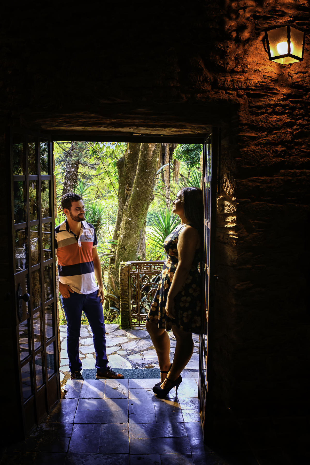 
casal de noivos em ensaio na porta noivo olhando para a noiva na Fazenda Arraial Velho em Sabará Minas Gerais 