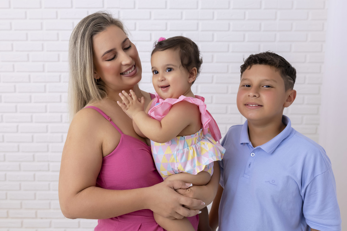 Bebê em ensaio Smash the Cake tema circo em estúdio fotográfico em Caraguatatuba, cenário colorido personalizado, bolo decorado, criança sorrindo e se divertindo durante sessão infantil
