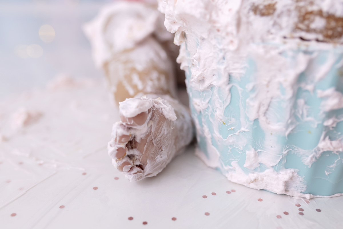 Bebê em ensaio Smash the Cake tema circo em estúdio fotográfico em Caraguatatuba, cenário colorido personalizado, bolo decorado, criança sorrindo e se divertindo durante sessão infantil